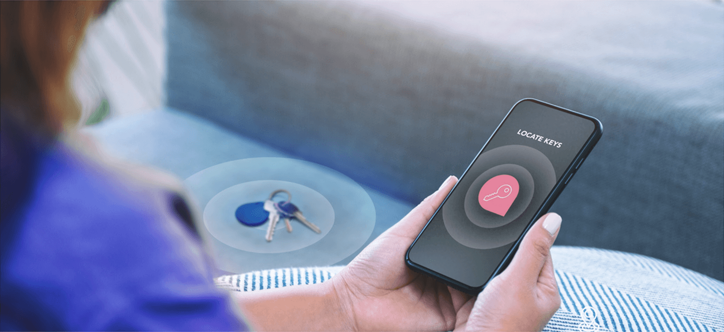 A person using a smartphone app to locate nearby keys on a couch.